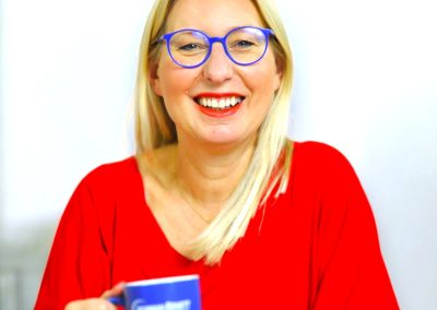 Akademia Coachingu Masterclass 6 Kobieta w czerwonej bluzce, uśmiechnięta.